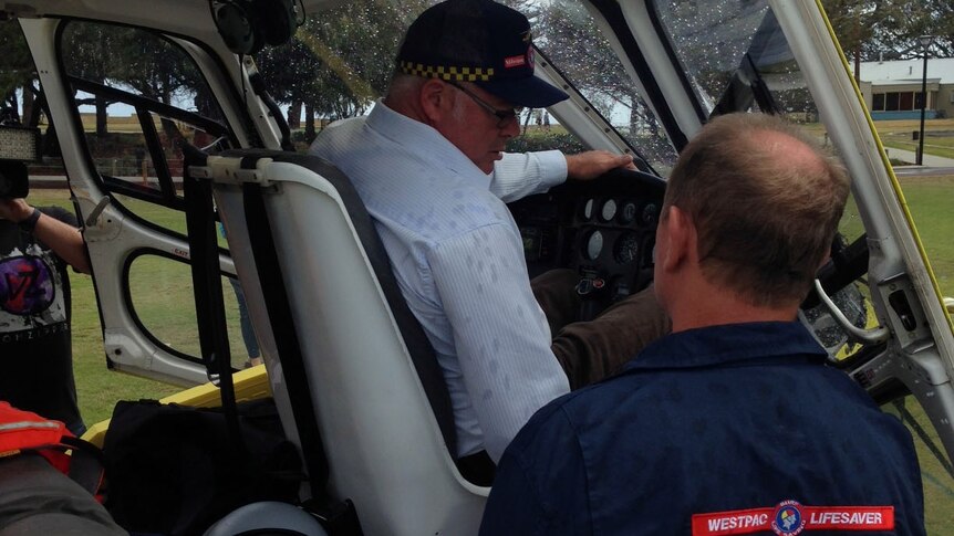Fisheries minister Troy Buswell inspects the south west beach patrol helicopter in Busselton before patrols start today.