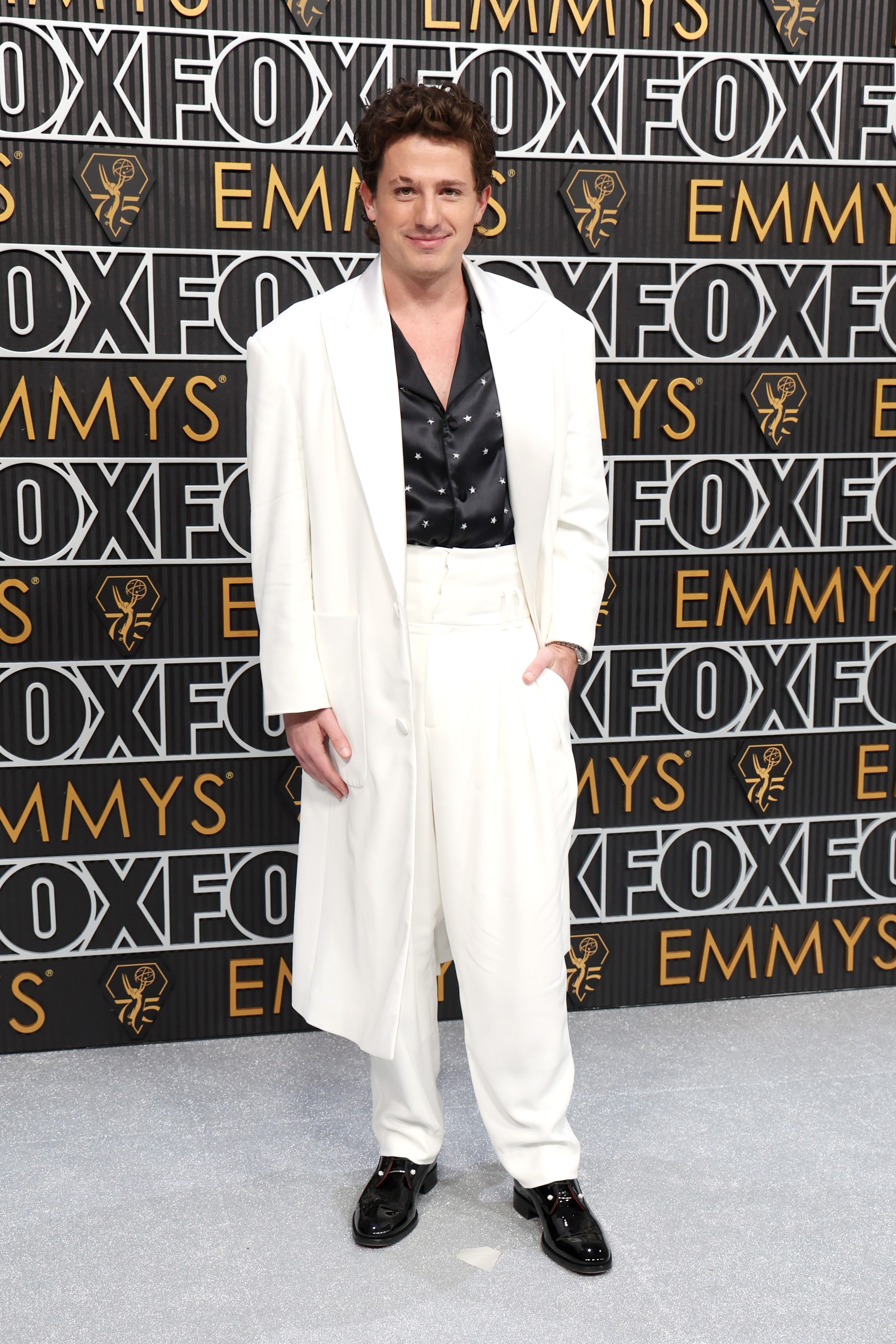 A man in a white suit on the red carpet