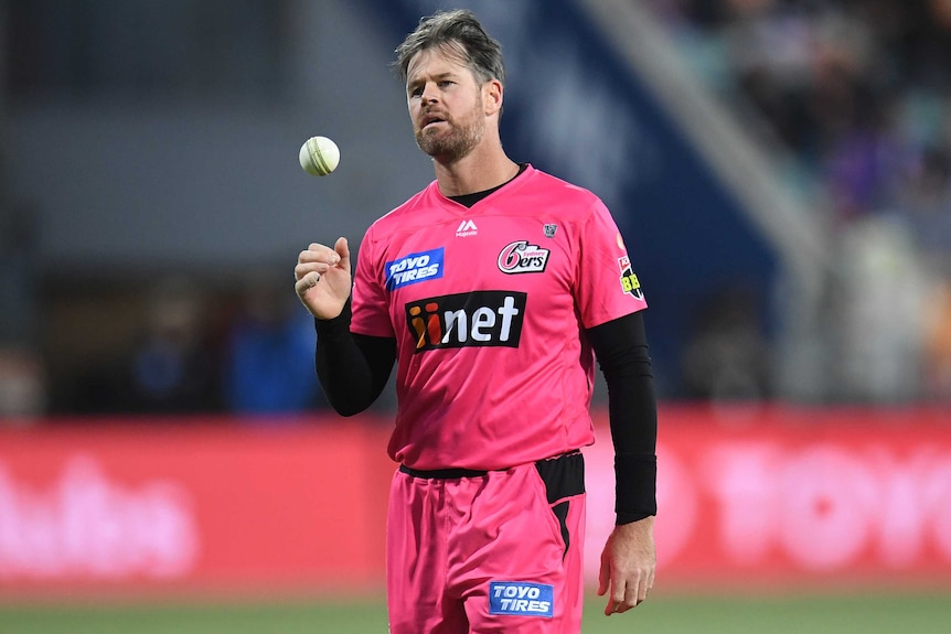 Dan Christian throws the ball in the air as he prepares to bowl for the Sydney Sixers.