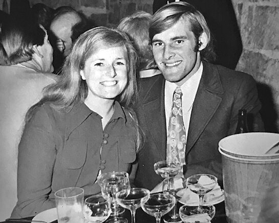 A black and white photograph of a couple seated at a dinner table