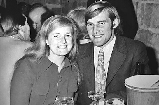 A black and white photograph of a couple seated at a dinner table