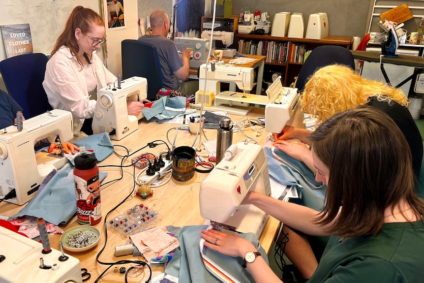 People sewing on machines in a class