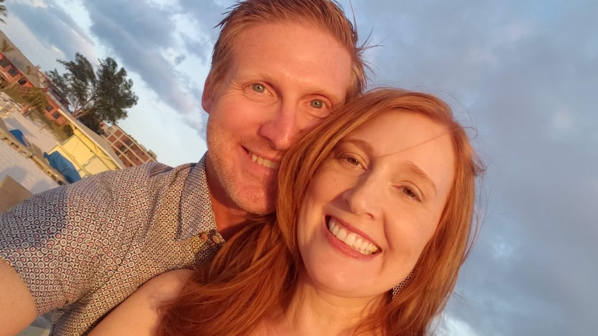 A man and woman take a selfie smiling at an angle