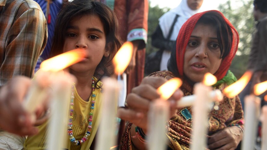 Pakistani civil society activists light candles during a rally in Karachi on December 23, 2014, held in solidarity with the victims of the Peshawar school massacre.