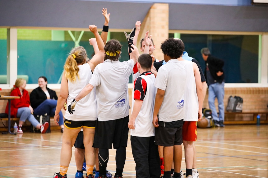 Team members rally together on the basketball court