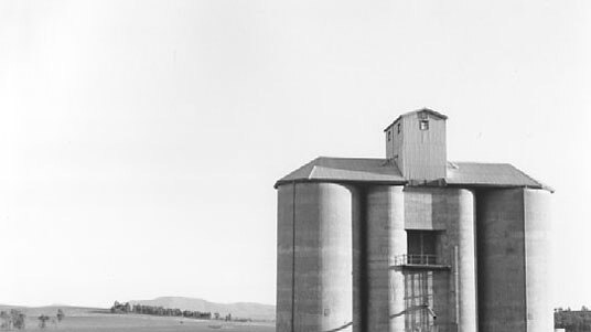 Black and white photograph of an old concrete silo