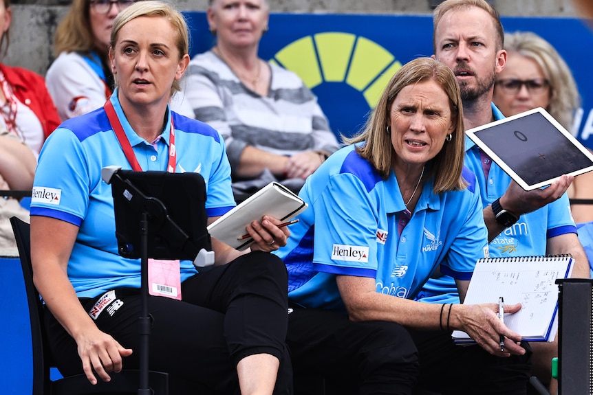 Tracey Neville and assistant Nicole Richardson sit on the bench as they watch their team play