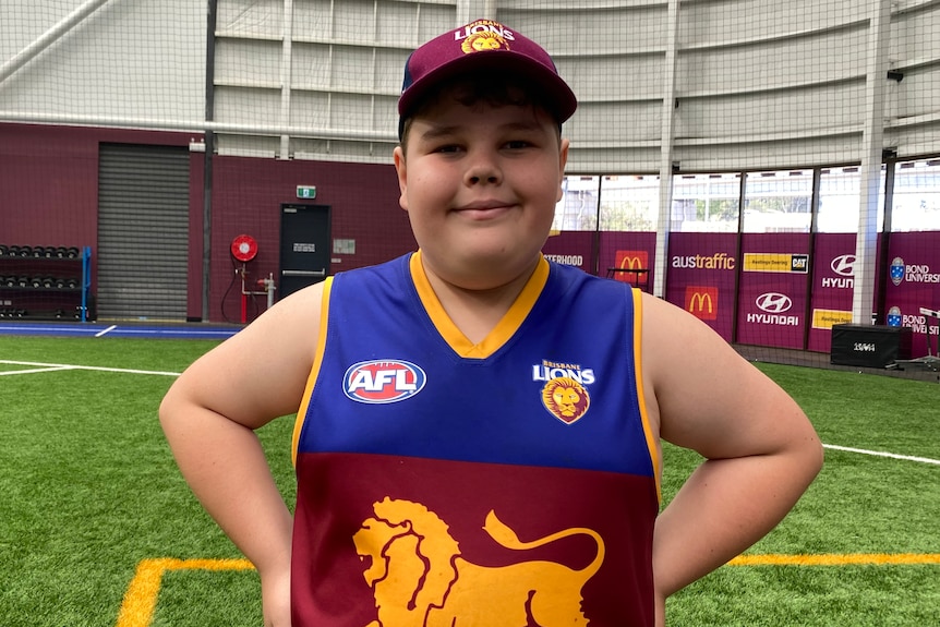 Jasper Sara wears a Brisbane Lions jersey and hat