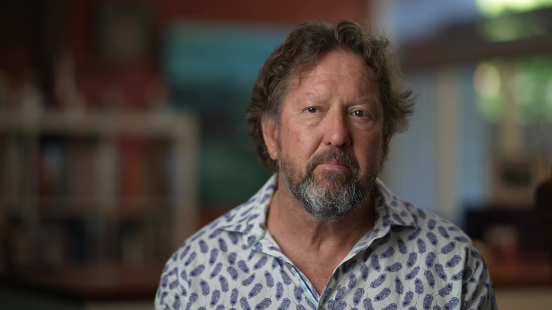 Foto de um homem vestindo uma camisa de colarinho branco com fundo desfocado.