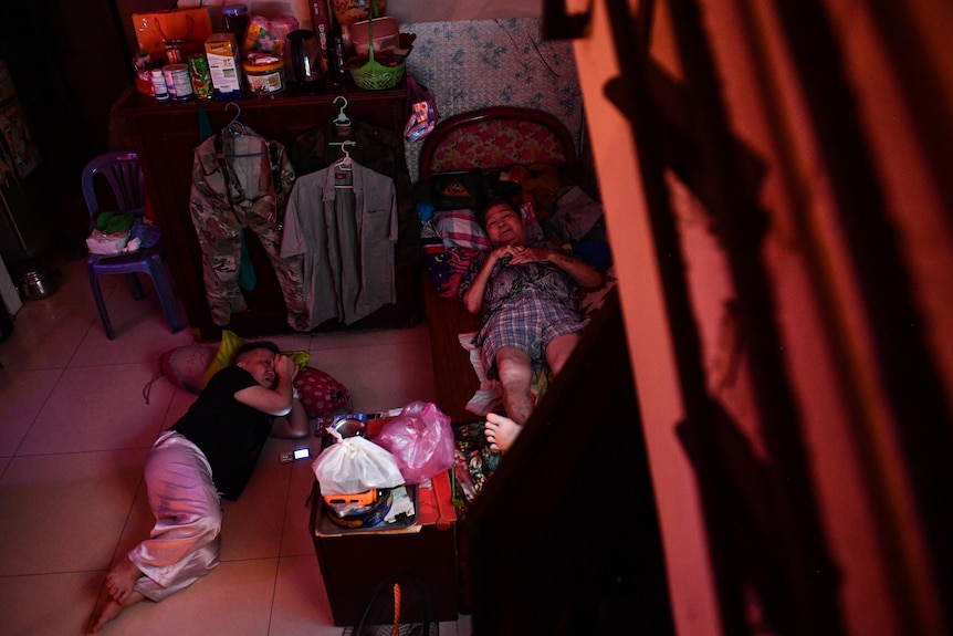 Binh Phan and his son sleep in their apartment one on the bed, one on the floor.