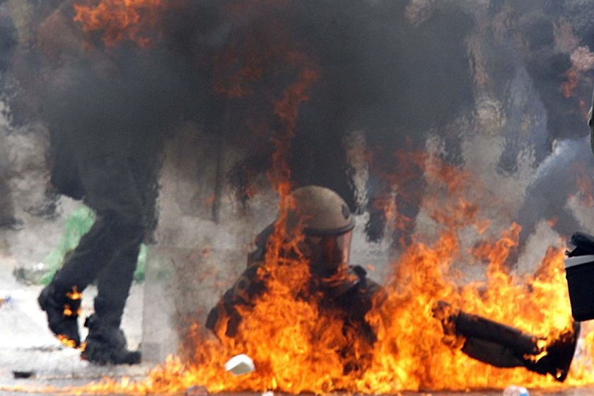 A riot policeman falls after being hit with a molotov cocktail