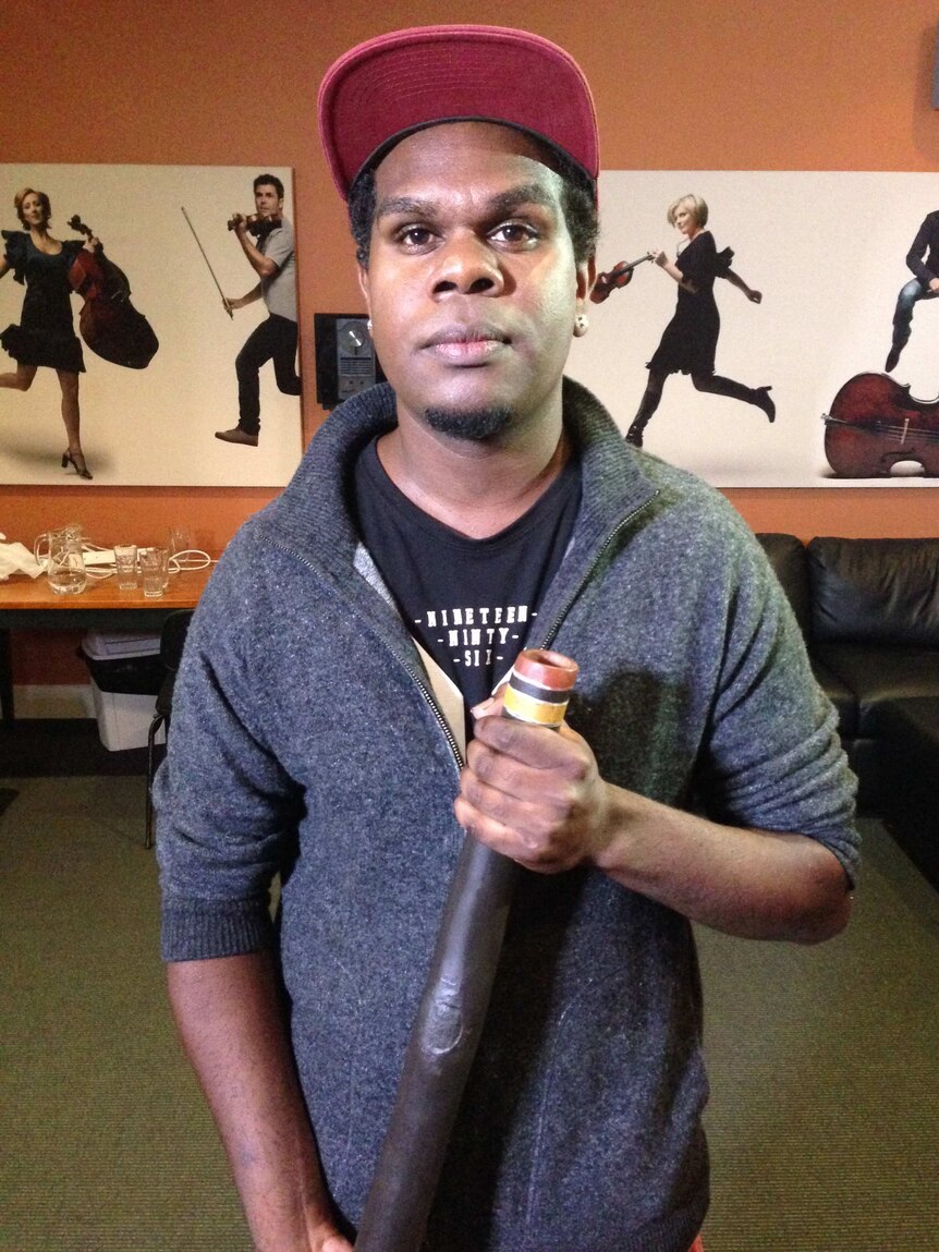 A portrait of Shelton Murray holding his didgeridoo.