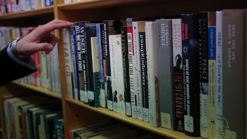 Liberal MP Andrew Hastie thumbs through books in the library at Parliament House. (April 2017)