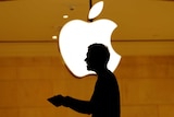 Customers walk past an Apple logo inside of an Apple store at Grand Central Station in New York.
