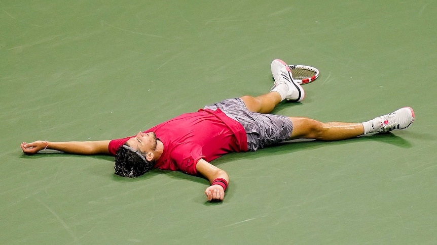 Dominic Thiem lies sprawled on the court.