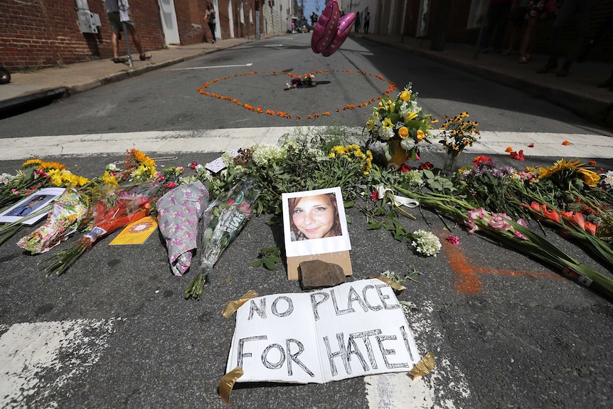 Flowers surround a photo of 32-year-old Heather Heyer, who was killed when a car hit a crowd of protesters in Charlottesville.