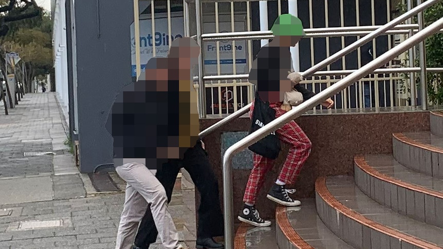 A teenage girl walks up stairs outside court in Perth followed by an older couple, with each of their identities pixellated