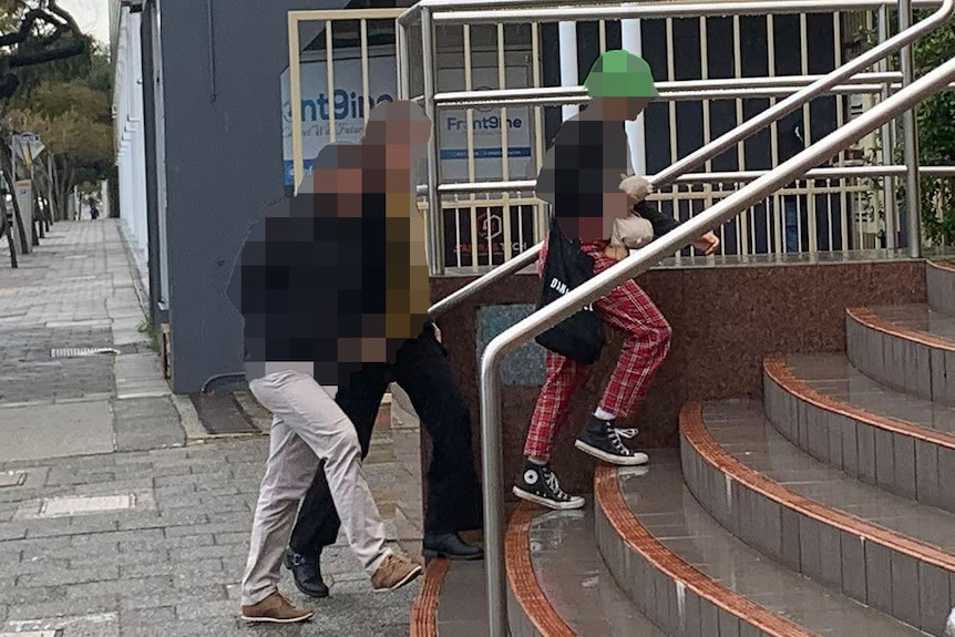 A teenage girl walks up stairs outside court in Perth followed by an older couple, with each of their identities pixellated