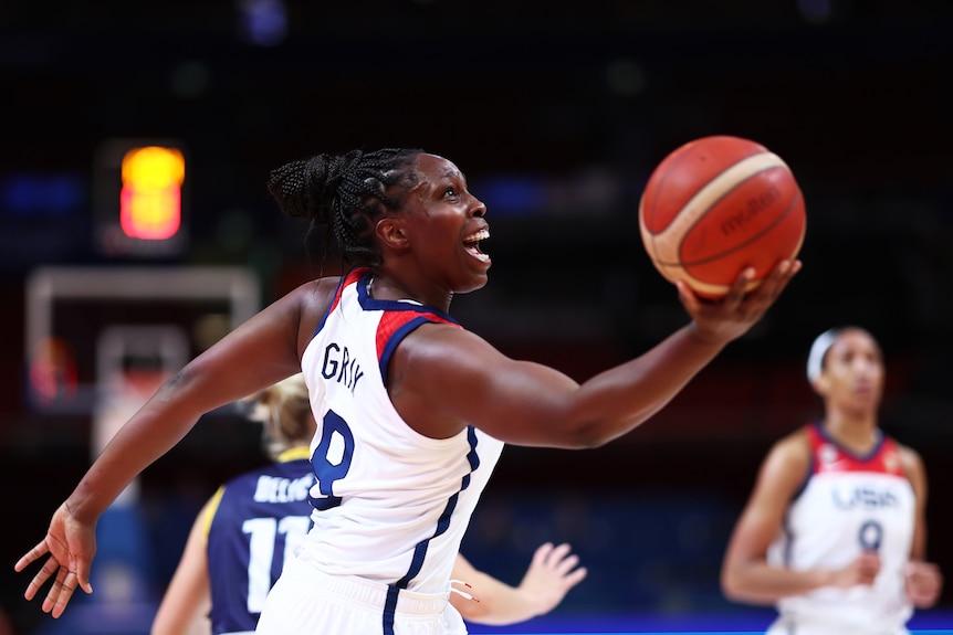 Chelsea Gray catches the ball and smiles.