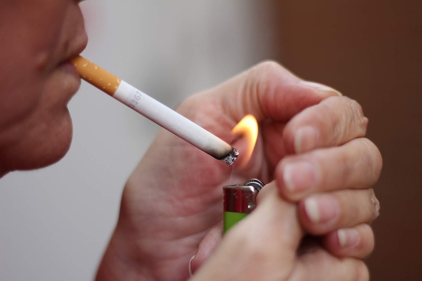 A smoker lights up a cigarette