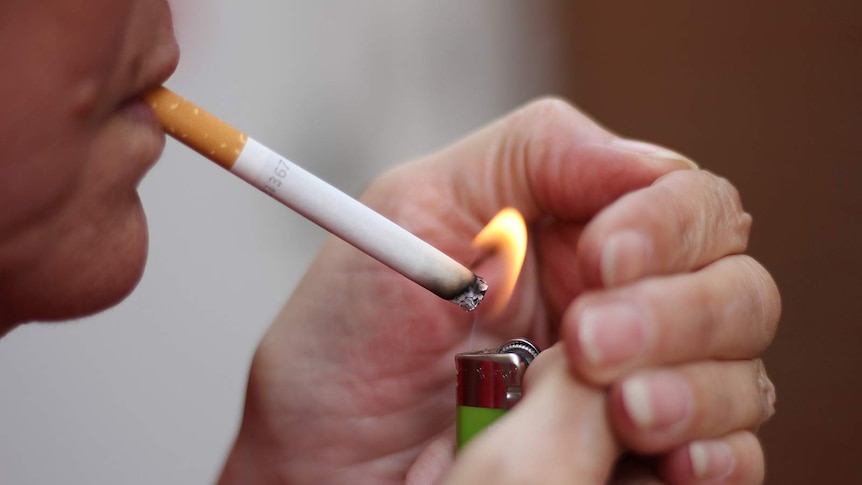 A smoker lights up a cigarette