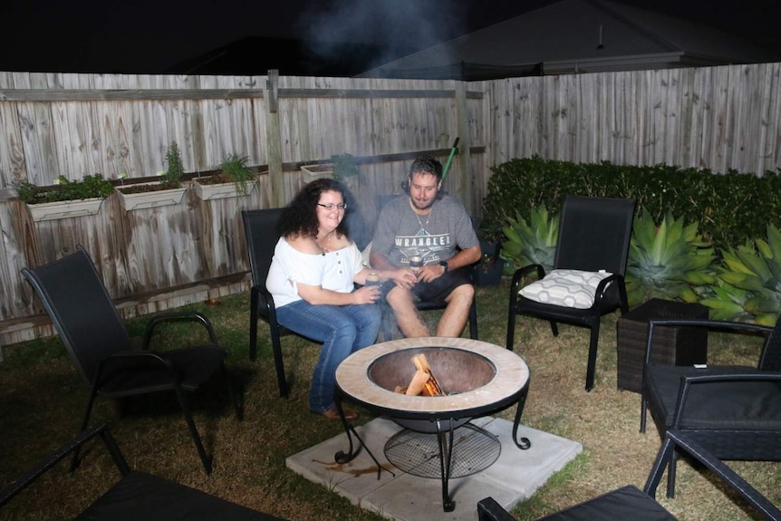 Cathy Smith and Mick Bliesner sit around the fire at their home in Burpengary, Caboolture.