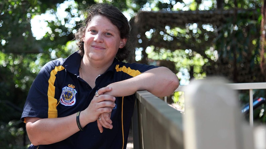 A photo of Invictus Games competitor Sam Gould leaning against a fence, smiling in sunlight.