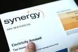 A person holding a Synergy bill.