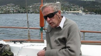 An older man sitting on a yacht.