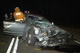 A silver car with its front section destroyed after hitting a tree.