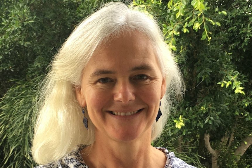 Denise Bond standing in front of a macadamia tree.