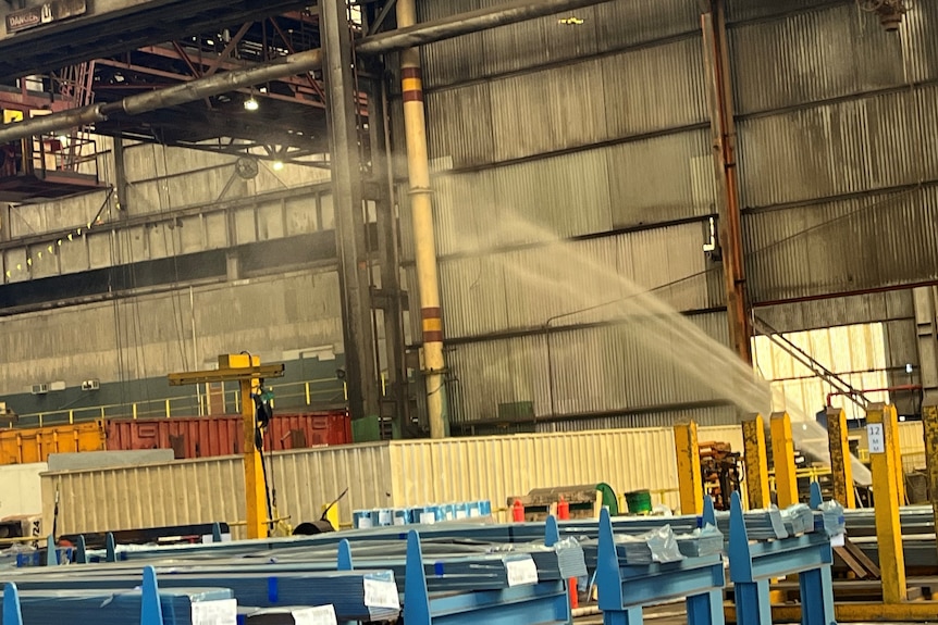 Inside a large warehouse where water cannons are spraying water