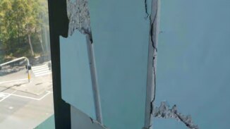A cracked, blue precast panel inside the Opal Tower building.