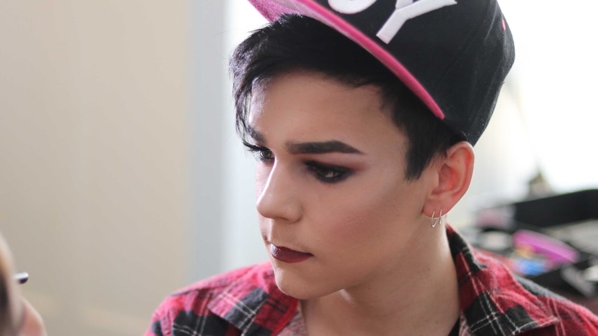 A young man with a cap on looking away from the camera