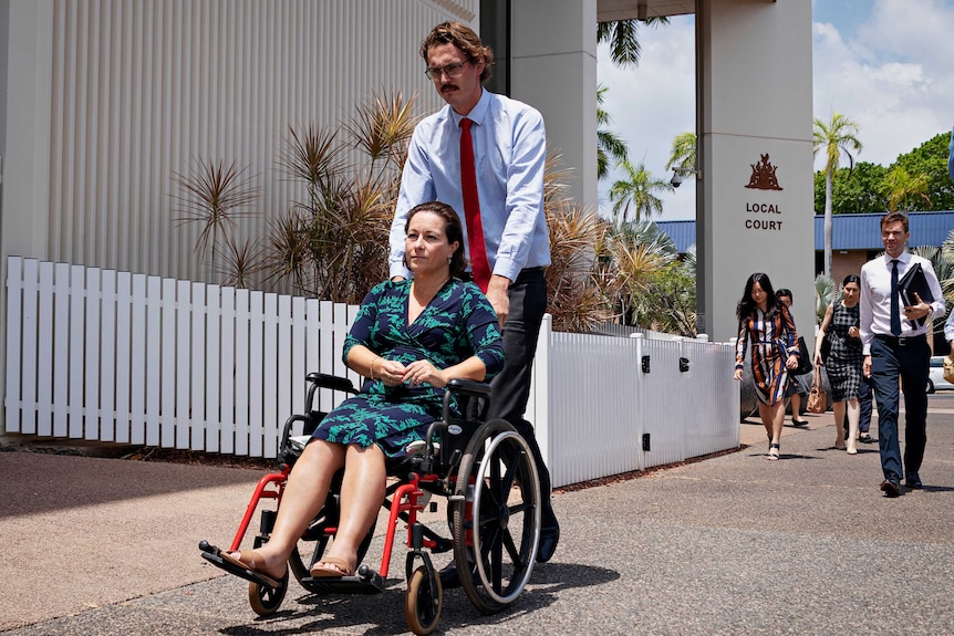 Karen Broadfoot is wearing a green and navy dress and is leaving local court. She is in a wheelchair.