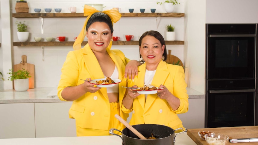 Aysha Buffett and her mum Josie Difuntorum hold a plate of chicken adobo each in a kitchen.