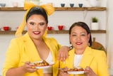 Aysha Buffett and her mum Josie Difuntorum hold a plate of chicken adobo each in a kitchen.