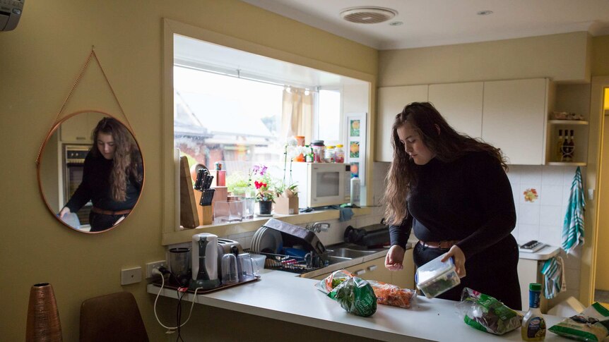 Molly Willmott makes lunch in her kitchen before heading to uni.