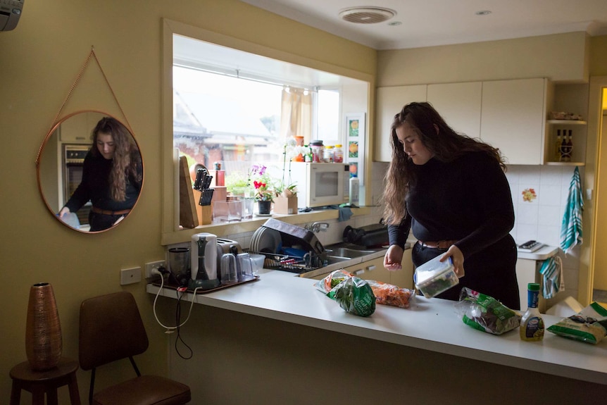 Molly Willmott makes lunch in her kitchen before heading to uni.