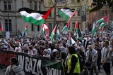 People holding Palestinian flags march during a rally in Sydney. 