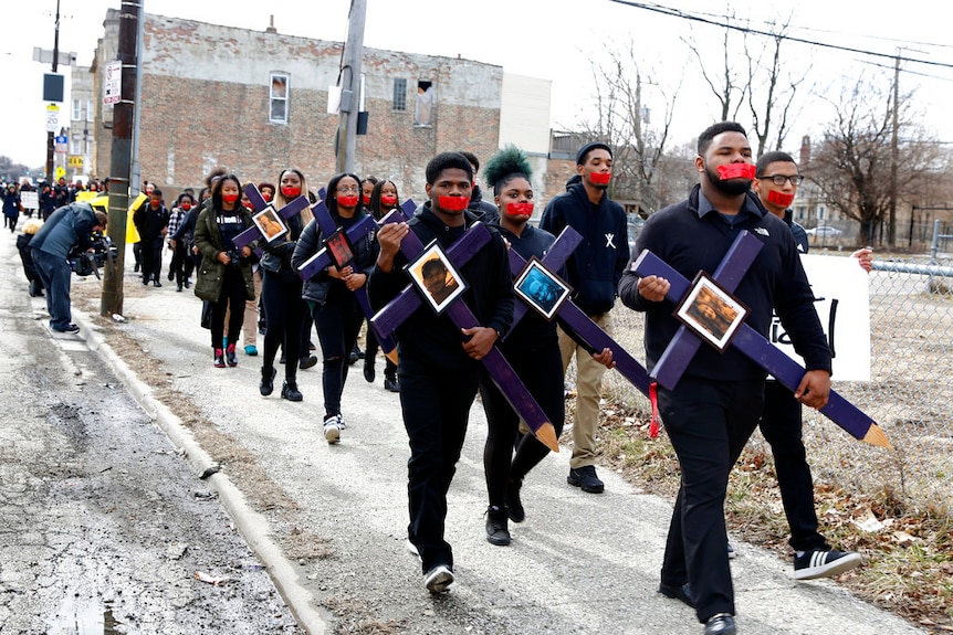 About 200 Chicago high schoolers carried crosses bearing images of people killed by gun violence.