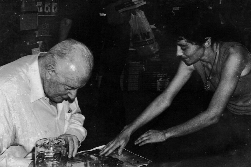 Australians for a Free East Timor member Jessie Watson asks Gough Whitlam to sign a photo depicting torture in Timor-Leste.