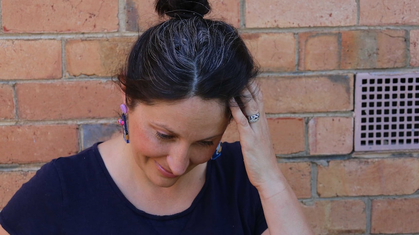 A dark haired with greying hair woman for a story about embracing grey hair during coronavirus isolation.