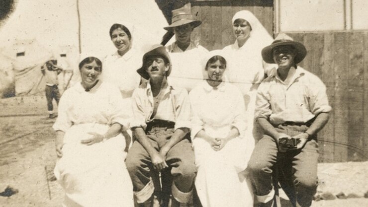 Group of nurses and patients sit outside a hospital