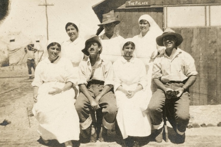 Group of nurses and patients sit outside a hospital