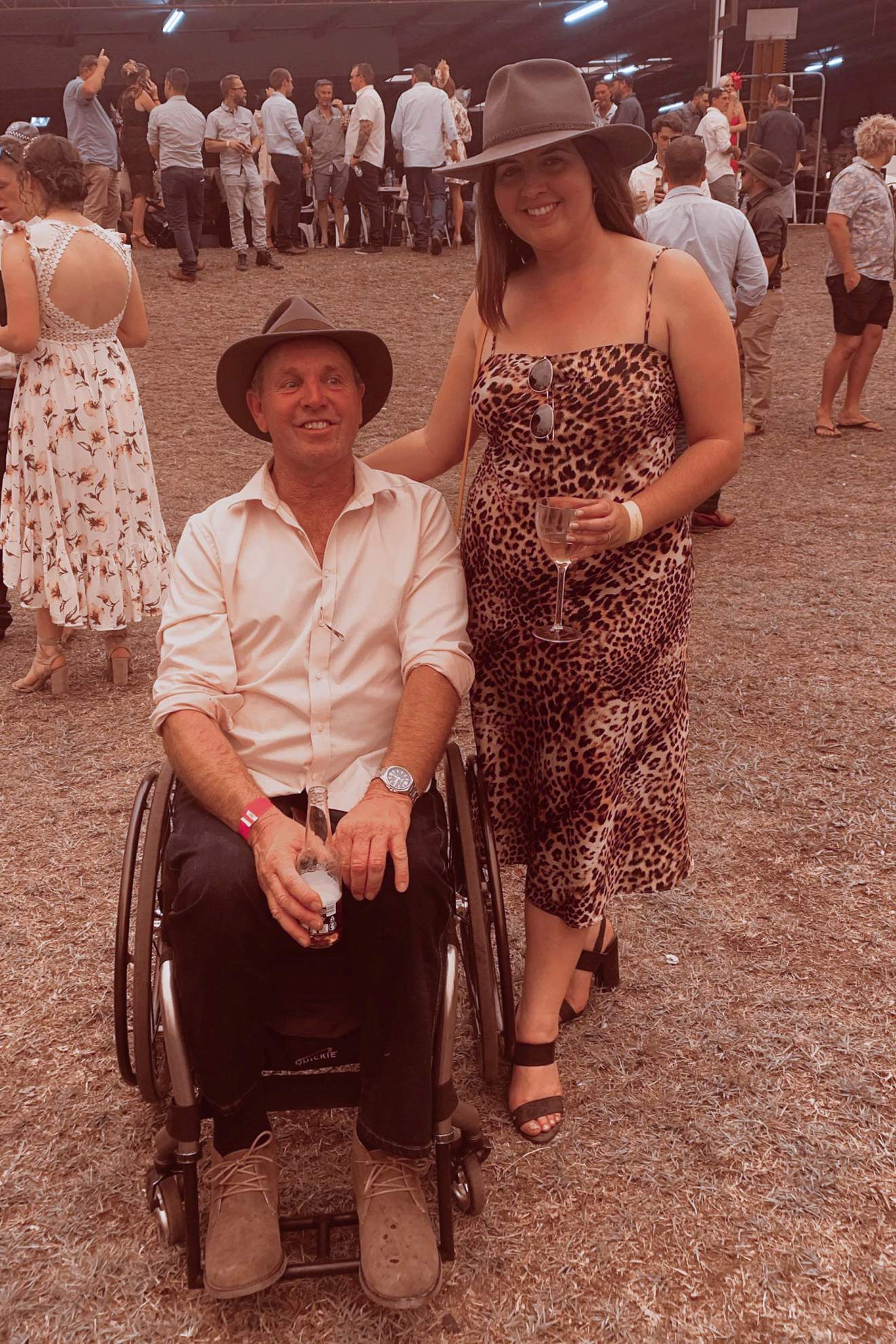 Un hombre en silla de ruedas, una señora parada a su lado.