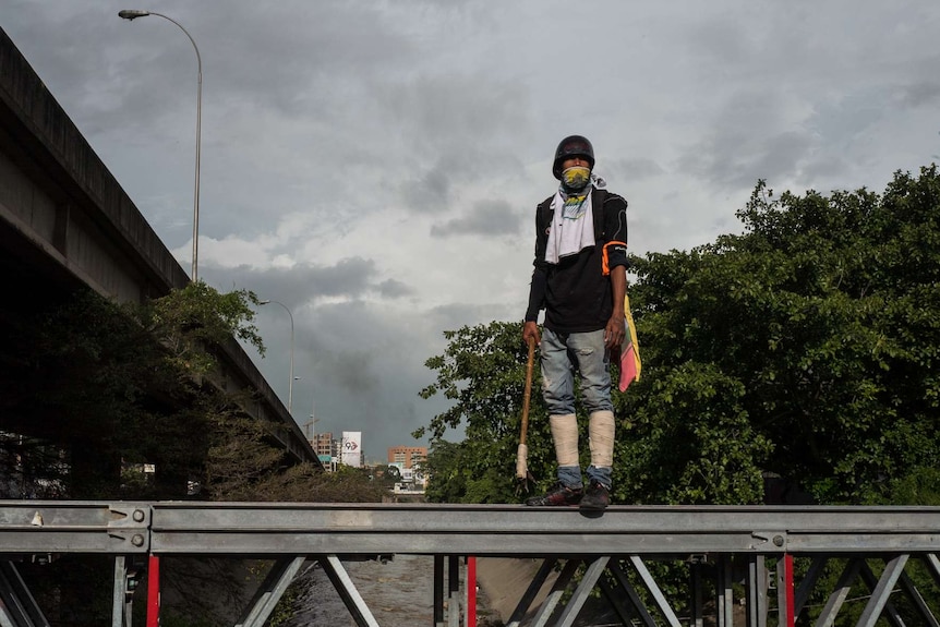 A protester stands defiantly after riot police were pushed back.