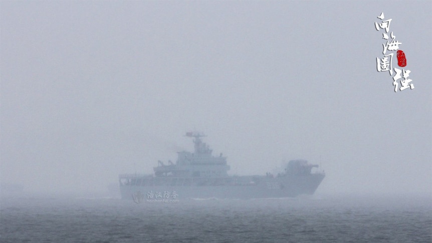 In deep fog out at sea, a Chinese warship is spotted with a railgun shaped close to a trapezium.