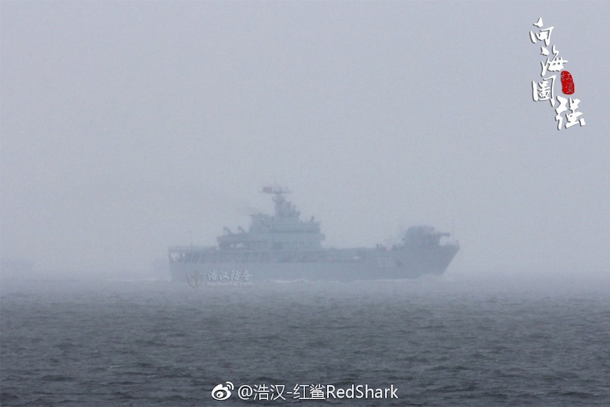 In deep fog out at sea, a Chinese warship is spotted with a railgun shaped close to a trapezium.