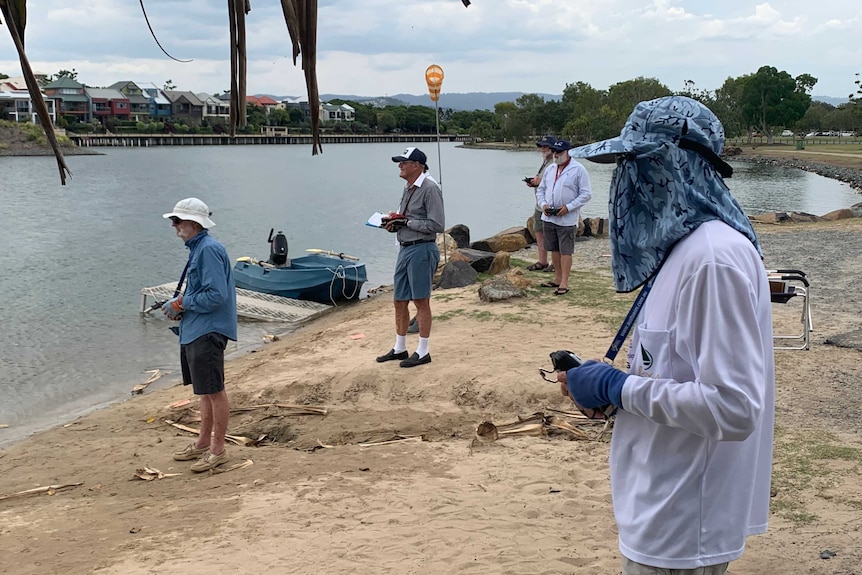 Paradise Radio Yacht Club members competing with remote controls for their boats at Emerald Lakes.